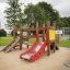 Playground structure for children with a red slide and wooden elements Mini play
