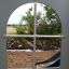 View through the window of the Windsor castle with slide showing sand and greenery.