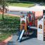 Camelot castle with slide playground equipment in park with climbing and sliding features