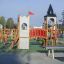 Tintagel playground castle with slides and climbing structures on a sunny day.