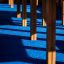 Wooden legs of Challenger-Aztec wooden playhouse cast shadows on blue floor.