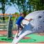 Boy climbing on Challenger- Aztec wooden playhouse in a playground.
