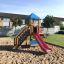 Logo Tower playhouse with slide on a sandy playground
