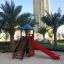 Logo Tower playhouse with slide in an urban park setting