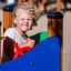 Child playing on Pi playground equipment with a red steering wheel.
