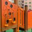 Smart playhouse with slide in orange with various shapes and climbing elements