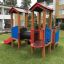 Smart playhouse with slide in playground setting.