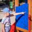 Young girl playing with an educational panel on a smart playhouse with slide.