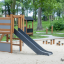 Natural wood and gray Grocer's single slide in a playground.