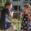 Two girls playing on Grocer's single slide playground equipment