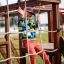 Child playing on Grocer's single sliderope playground structure.