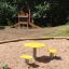 Yellow Daisy playground table and chairs set in a sandbox area.