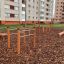Parallel bar outdoor exercise equipment in a playground area with woodchip ground cover