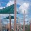Sun Shade Triangle 3x3x3 Nature (Robinia) installed in a playground area with wooden supports.