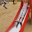 Child sliding down the Single Swing with Tower single slide in a playground.