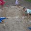 Children playing in a Dino sandbox base, digging and exploring.