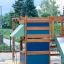 Climbing Kiosk wooden play structure with climbing elements and slide on playground.