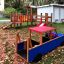 Wooden Truck playground equipment with slide and climbing structure.
