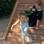 Children playing on Wigwam wooden house playground.