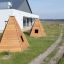Wigwam wooden house for children in a garden setting.