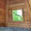 Wigwam wooden house interior with a window view of green trees