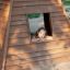 Child enjoying playtime inside a Wigwam wooden house.