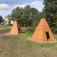 Wooden Wigwam houses in a park setting.