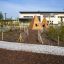 Wigwam wooden house in a landscaped garden area at a playground.