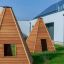 Two Wigwam wooden houses on green grass.