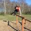 Woman jumping over Double Jump Bars in a park.