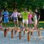 Wooden balance beams playground equipment Hip Hop with children playing on sand.