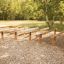 Outdoor fitness equipment Hip Hop with wooden balance beams on a wood chip ground.