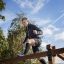 Man climbing on Climb Obstacle wooden ladder in an outdoor park.