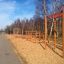 Climb Obstacle wooden ladder on outdoor playground with trees in the background.