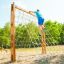 Boy climbing on a V-shape Net Large climbing net in an outdoor playground.