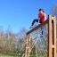 Woman climbing V-shape Net Large climbing net in outdoor playground.