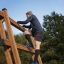 Man climbing Step And Climb wooden ladder outdoors.