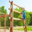 Boy climbing the Step And Climb wooden ladder in a playground.