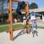Children playing on Step And Climb wooden ladder in a playground.