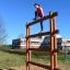 Woman climbing Step And Climb wooden ladder in outdoor playground.