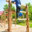 Children climbing on Step And Climb wooden ladder in a playground.
