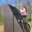 Woman climbing the Climbing Ramp steel structure in an outdoor playground.