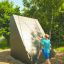Boy climbing on Climbing Ramp steel structure in outdoor playground.