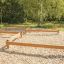 Wooden balance beams in an outdoor playground area.