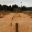 Outdoor wooden balance playground equipment in a forest area.