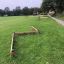 Outdoor wooden Balance obstacle course equipment on a green field.