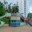 Majestic ship with slide in a playground with green and blue colors, surrounded by trees and buildin