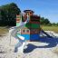 Majestic ship with slide in playground surrounded by green area and trees