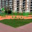 Green Single Swing playground equipment in a modern residential area.