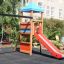 Double Swing with Tower playhouse with slide in a backyard setting